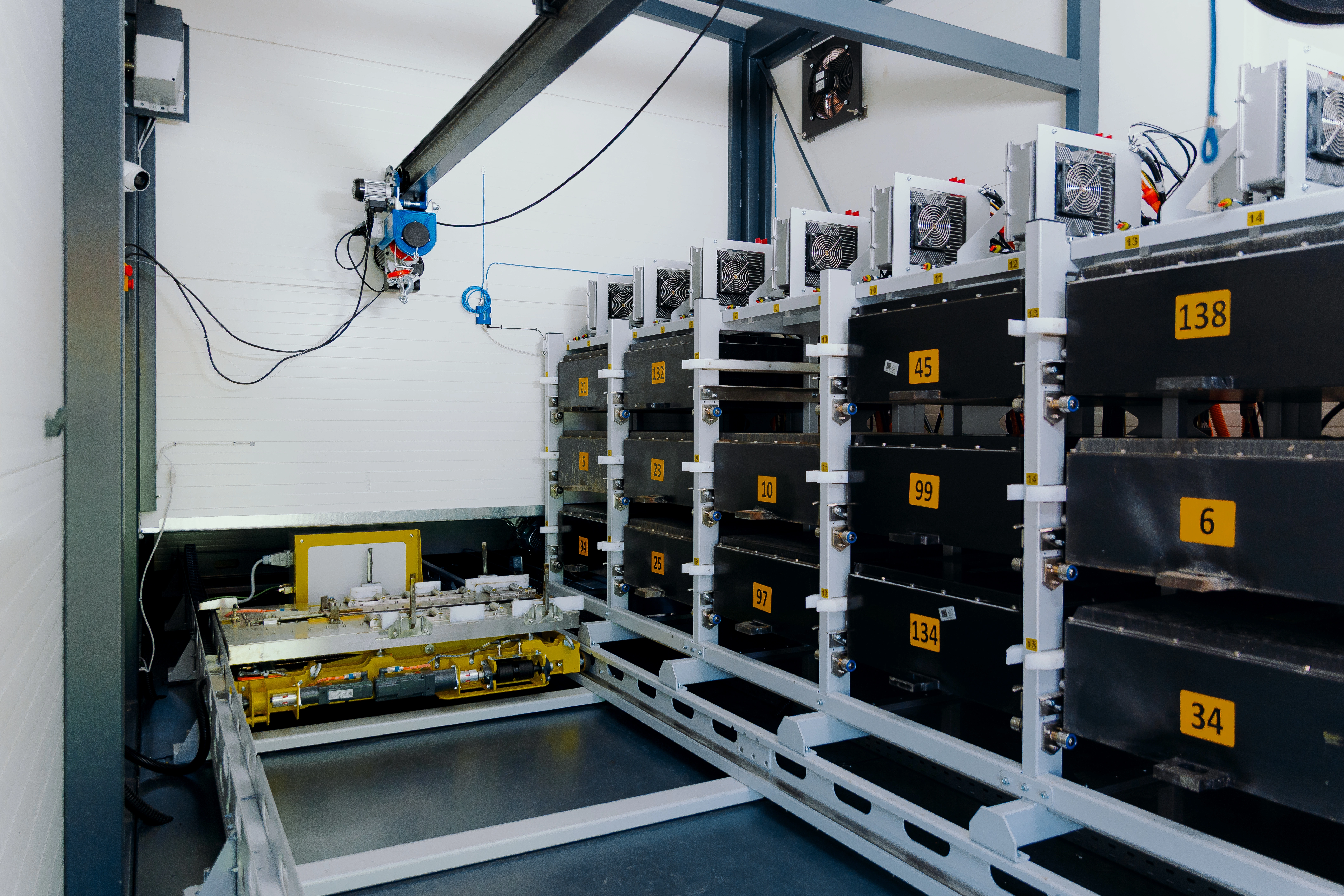 Numbered battery packs on charging racks inside the swap station