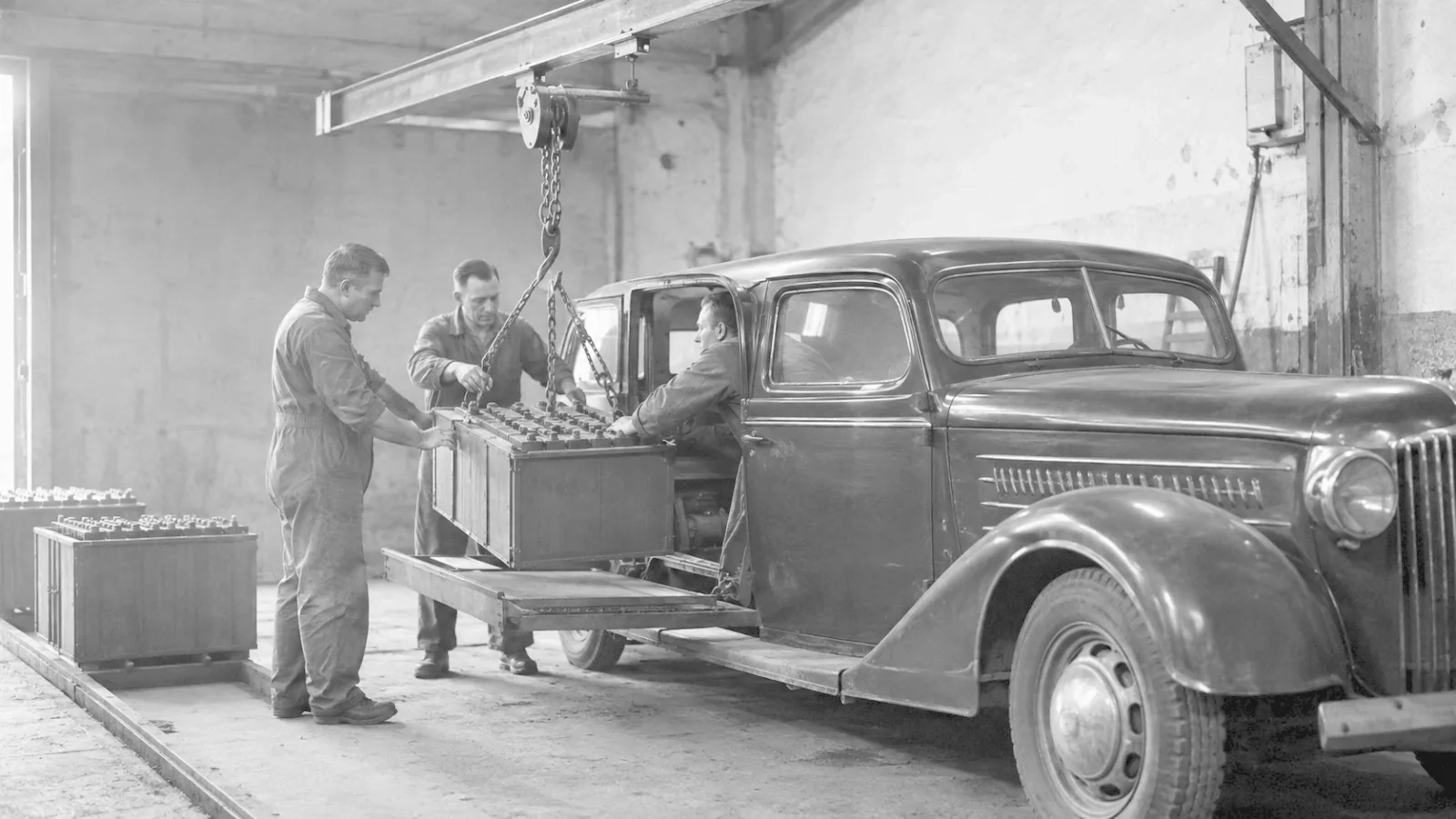 Battery being lifted out of a car in a garage on a chain hoist