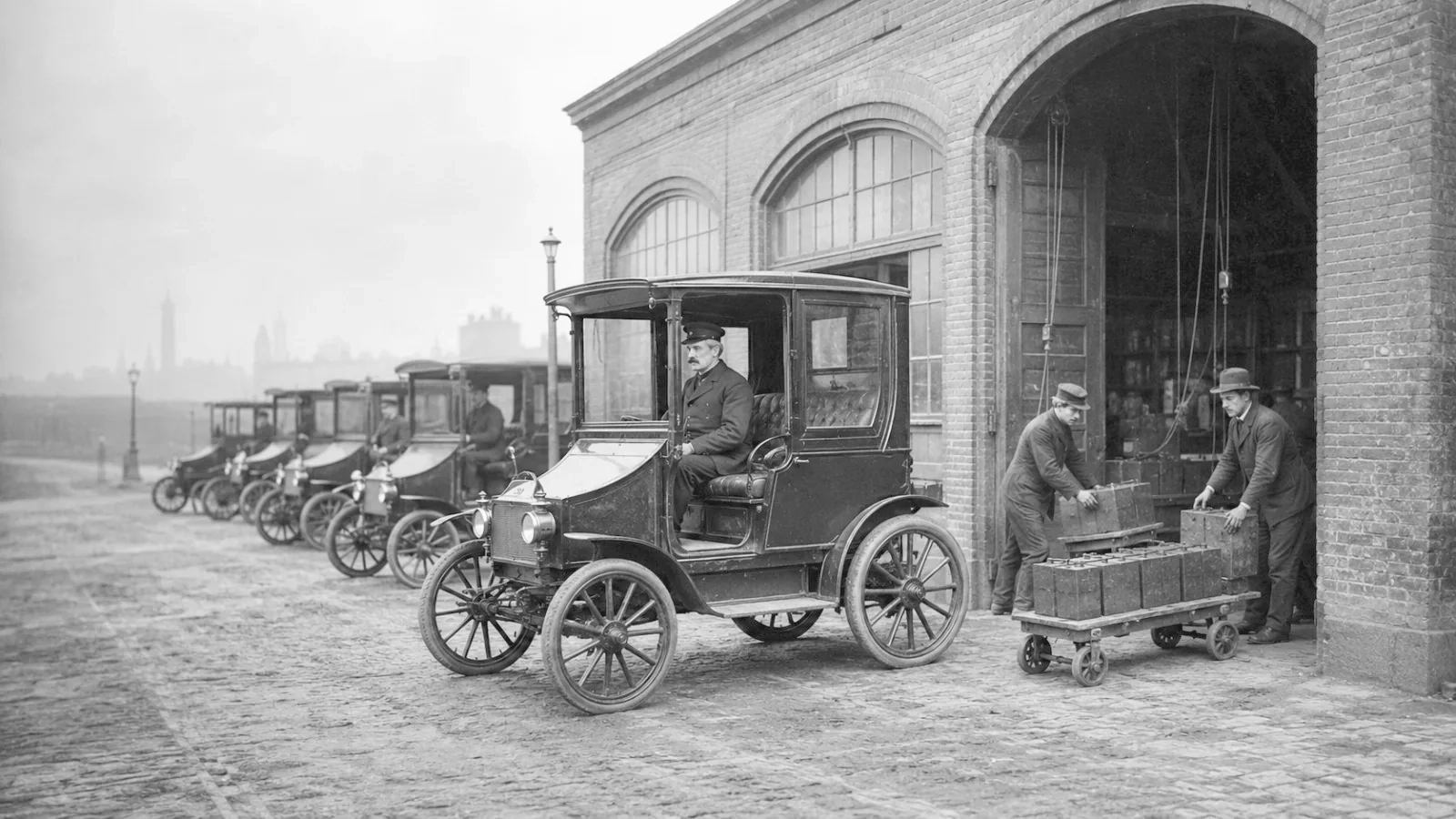 Electric taxi depot, crews carrying battery crates on a trolley