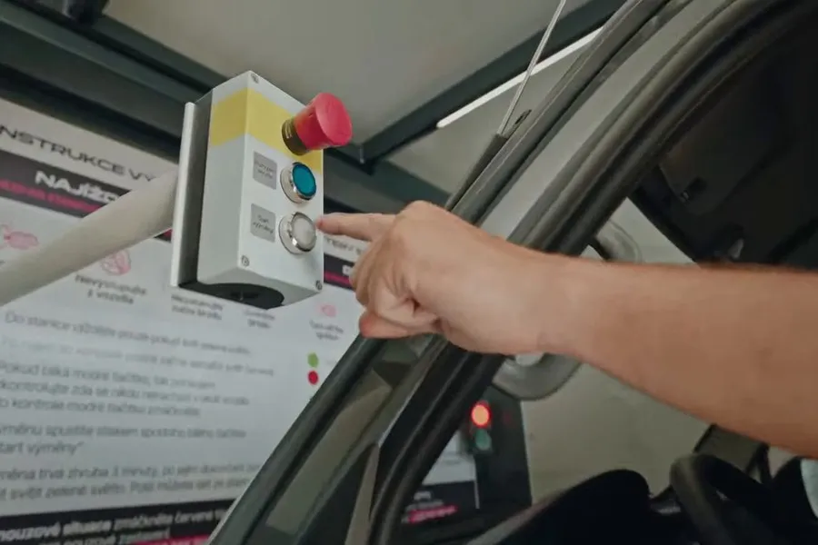 A hand pressing the control button on the swap station panel